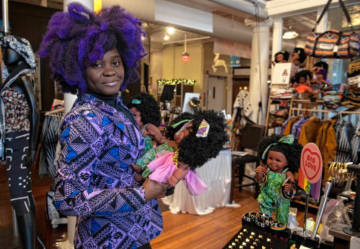 Aimee Salmon, owner if Positively Africana in Thornes AMarketplace in Northampton, holds some of the many dolls she sells in her shop. PIC: DAILY HAMPSHIRE GAZETTE