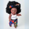 The Aimee Doll standing in Black Afro Hair and Branded Jumpsuit - dark skin color The Aimee Doll in Black Afro Hair and Branded Jumpsuit - dark skin color