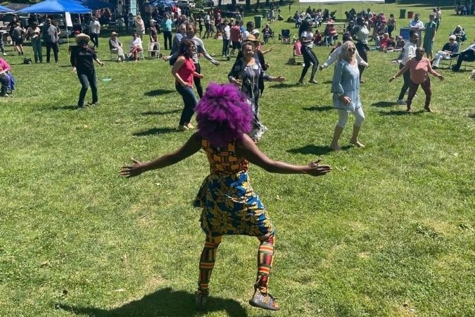Aimee Salmon leading a group of people at a fair in a fitness session.