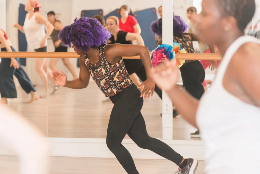 Studio fitness class in action. Community moving together with high energy.
